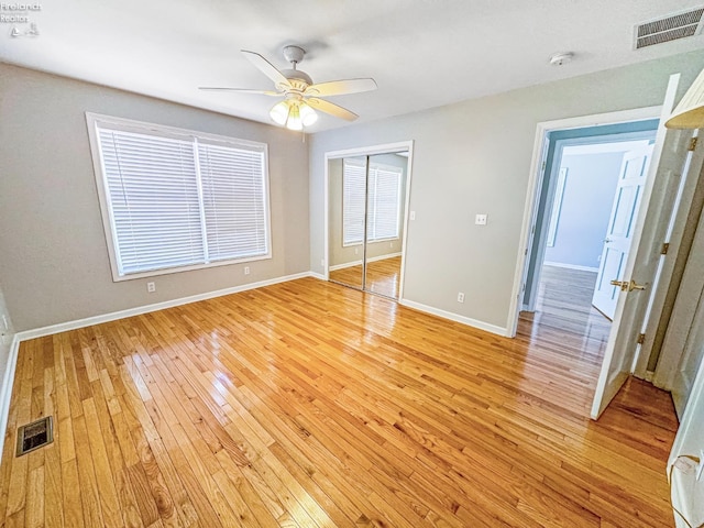 unfurnished bedroom featuring ceiling fan, a closet, and light hardwood / wood-style flooring