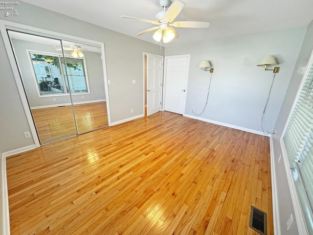 unfurnished bedroom featuring light wood-type flooring, ceiling fan, and a closet