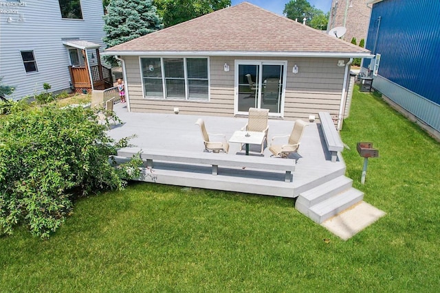 rear view of property with a wooden deck and a lawn