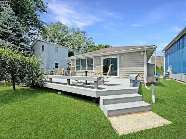 rear view of property featuring a lawn and a deck