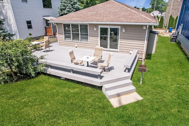 rear view of property featuring a yard and a deck