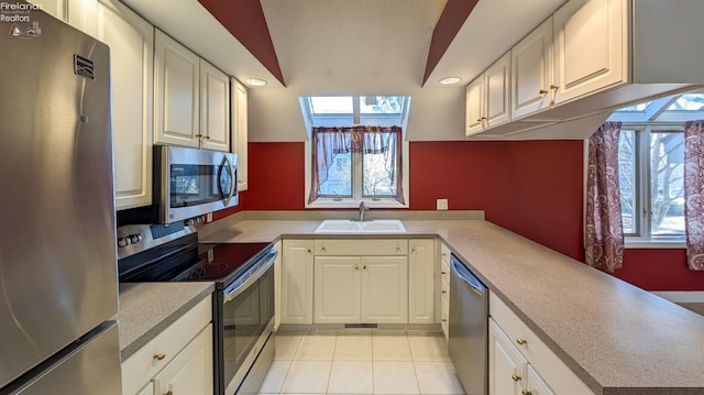 kitchen with stainless steel appliances, sink, and white cabinets