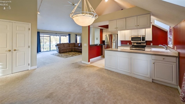 kitchen featuring stainless steel appliances, decorative light fixtures, light carpet, and white cabinets