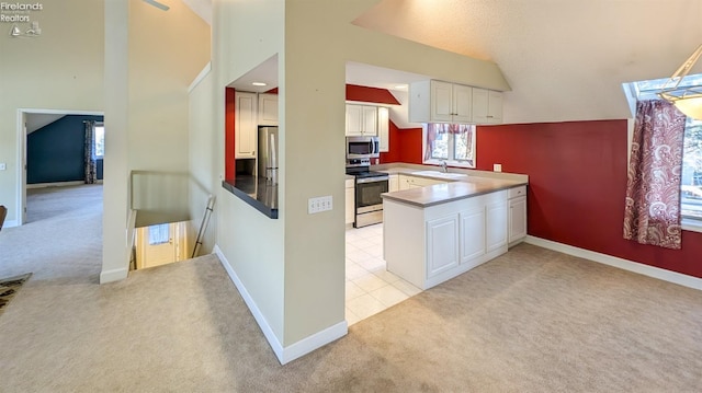 kitchen featuring sink, white cabinetry, light carpet, kitchen peninsula, and stainless steel appliances