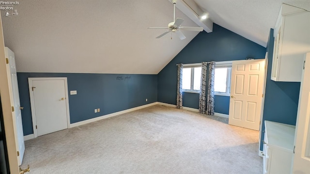 additional living space featuring ceiling fan, light colored carpet, lofted ceiling with beams, and a textured ceiling