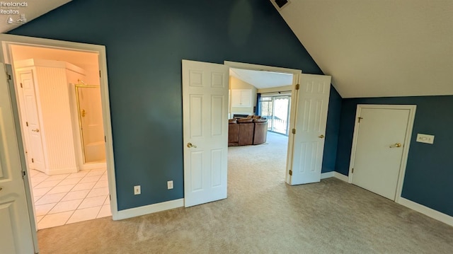 unfurnished bedroom featuring vaulted ceiling and light carpet