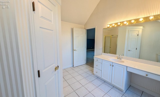 bathroom with tile patterned flooring, vanity, vaulted ceiling, and an enclosed shower