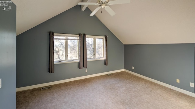 additional living space with lofted ceiling with beams, ceiling fan, and carpet flooring