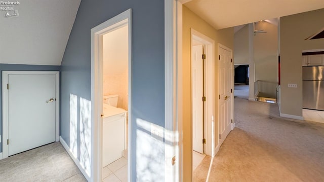 hallway with vaulted ceiling and light carpet