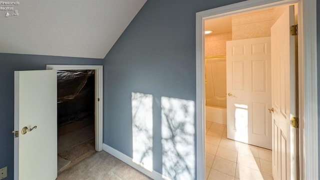 interior space featuring vaulted ceiling and light tile patterned floors