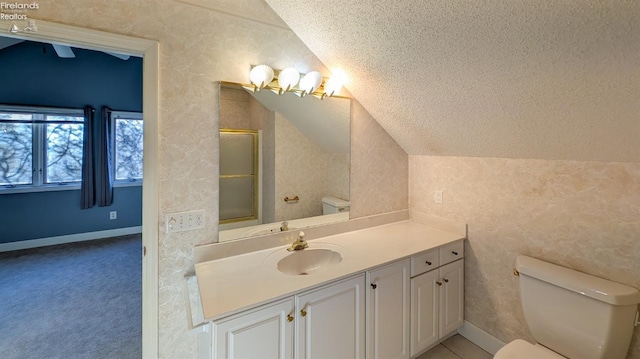 bathroom with lofted ceiling, vanity, walk in shower, toilet, and a textured ceiling