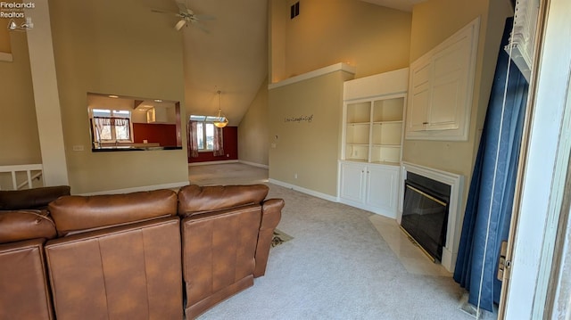 living room with light colored carpet and high vaulted ceiling