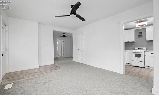 unfurnished living room featuring light colored carpet and ceiling fan