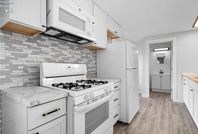 kitchen featuring white cabinetry, backsplash, white appliances, and light hardwood / wood-style flooring