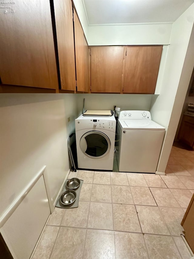 laundry area with cabinets, washer and dryer, and light tile patterned floors