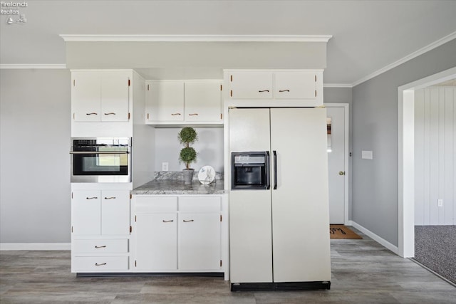 kitchen featuring light hardwood / wood-style flooring, white cabinetry, white refrigerator with ice dispenser, ornamental molding, and stainless steel oven