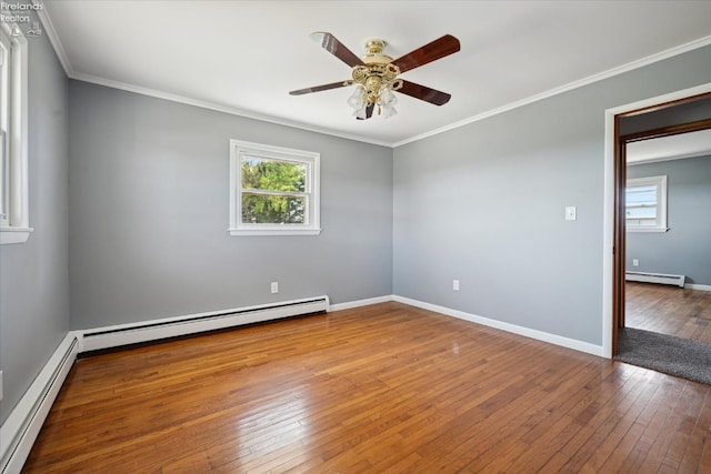 spare room featuring a baseboard heating unit, hardwood / wood-style flooring, and a healthy amount of sunlight