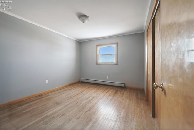 unfurnished room with crown molding, wood-type flooring, and baseboard heating