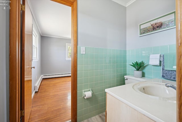 bathroom with hardwood / wood-style floors, vanity, tile walls, and crown molding