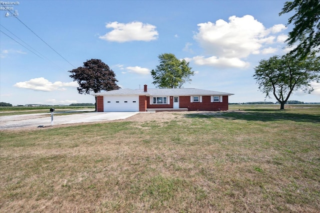 single story home with a garage, a front yard, and a rural view