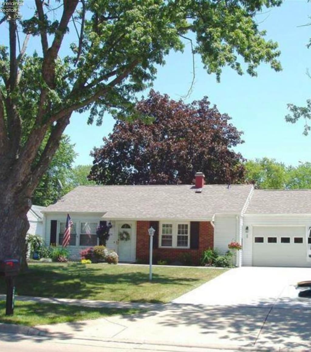 ranch-style house featuring a garage and a front lawn