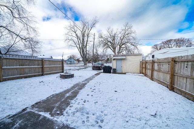 yard layered in snow featuring a fire pit