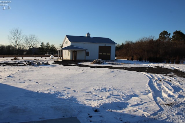 snow covered property with a garage