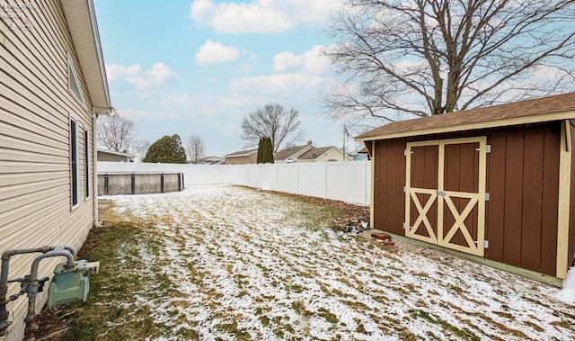 yard covered in snow featuring a storage shed