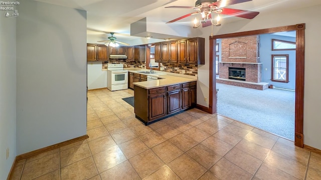 kitchen featuring sink, white range with electric cooktop, a baseboard heating unit, light colored carpet, and kitchen peninsula