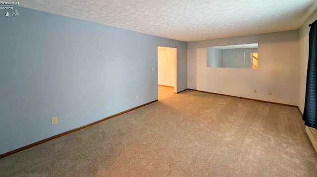 empty room featuring light carpet and a textured ceiling