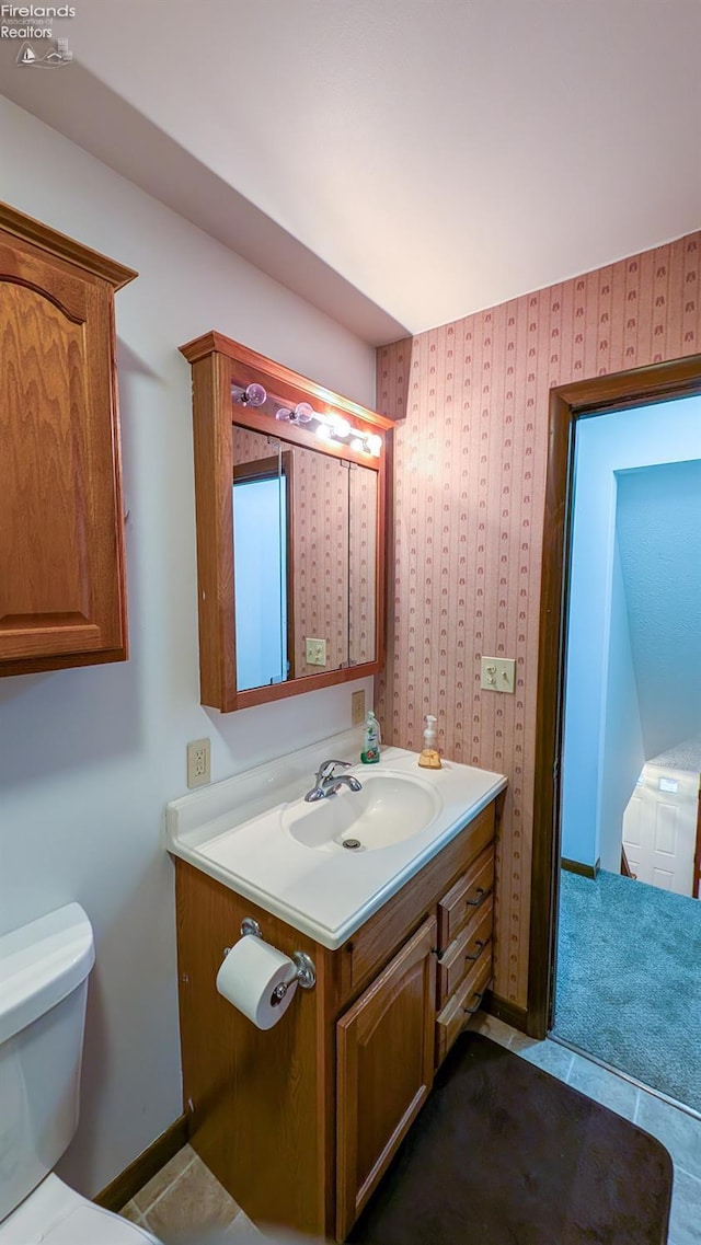 bathroom featuring tile patterned floors, vanity, and toilet