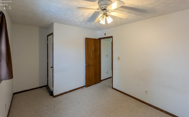 unfurnished bedroom with ceiling fan, light colored carpet, and a textured ceiling