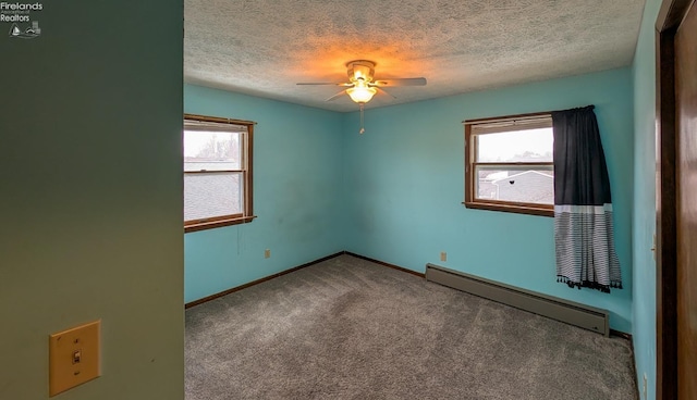 carpeted empty room featuring a baseboard radiator, a wealth of natural light, a textured ceiling, and ceiling fan