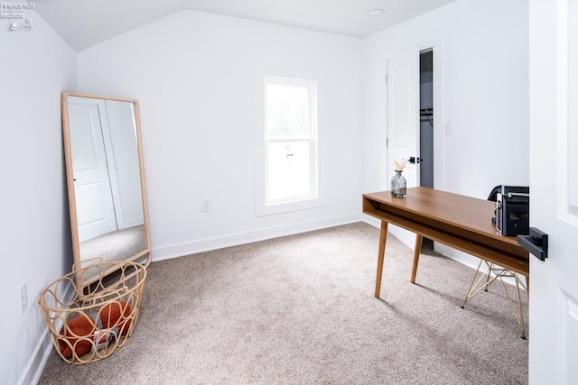 carpeted office space featuring vaulted ceiling