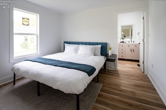 bedroom featuring wood-type flooring and connected bathroom