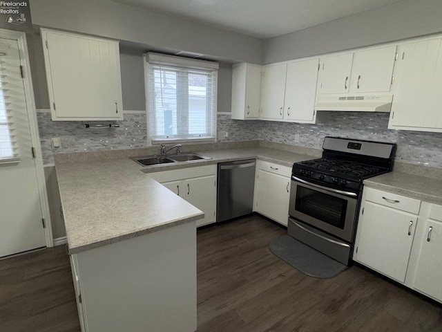 kitchen with stainless steel appliances, white cabinetry, sink, and kitchen peninsula