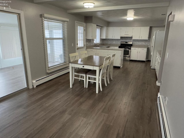 kitchen featuring white cabinetry, sink, stainless steel stove, and baseboard heating