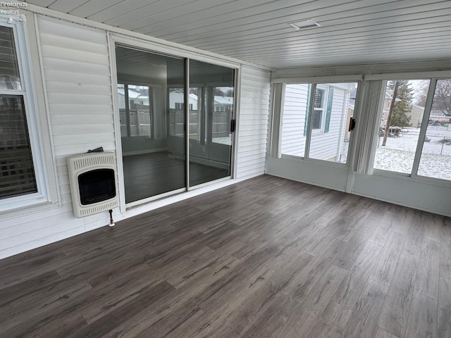 unfurnished sunroom featuring heating unit and wood ceiling