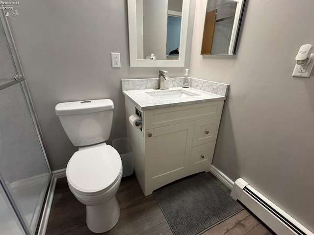 bathroom with vanity, a baseboard heating unit, wood-type flooring, and toilet