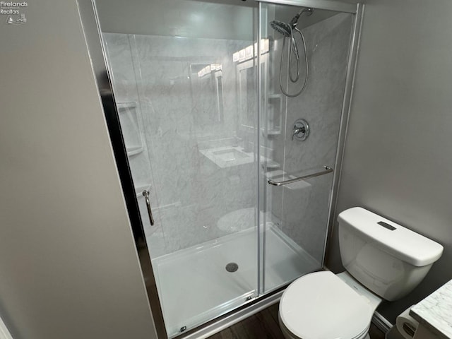 bathroom with toilet and an enclosed shower