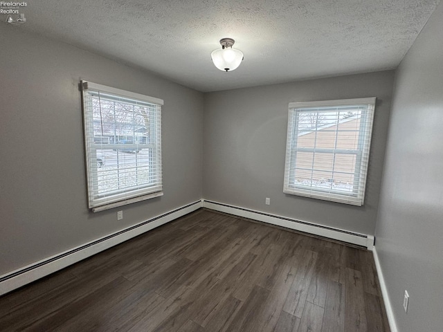 spare room featuring wood-type flooring, a textured ceiling, and baseboard heating