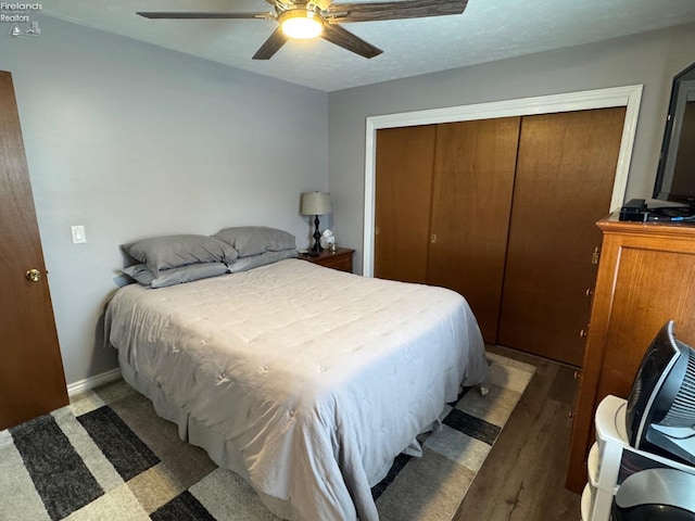 bedroom featuring dark hardwood / wood-style floors, a textured ceiling, ceiling fan, and a closet