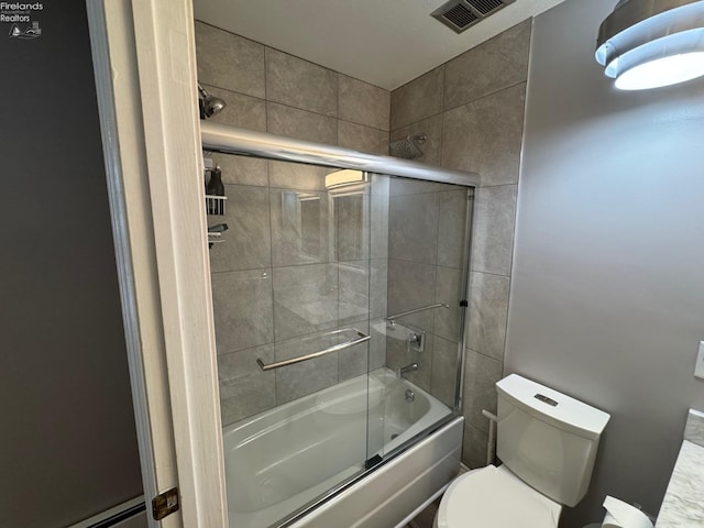 bathroom with bath / shower combo with glass door, a baseboard radiator, and toilet