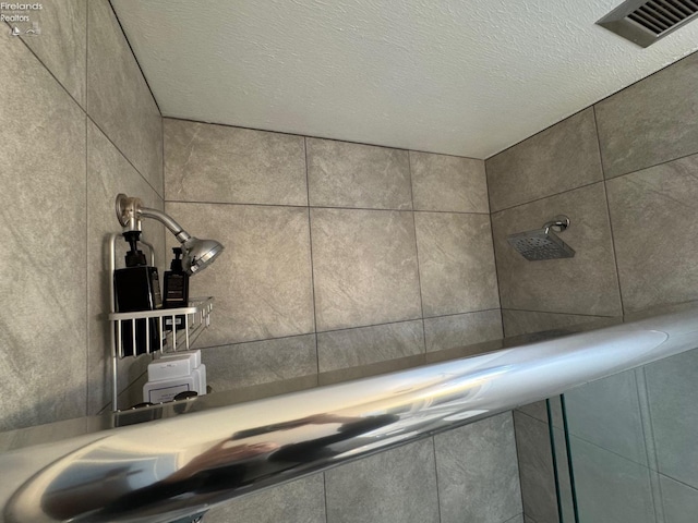 room details with a shower and a textured ceiling