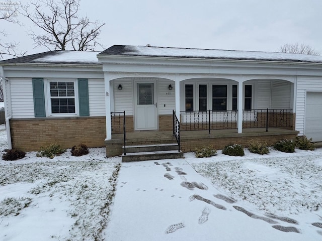 ranch-style home with a garage and covered porch