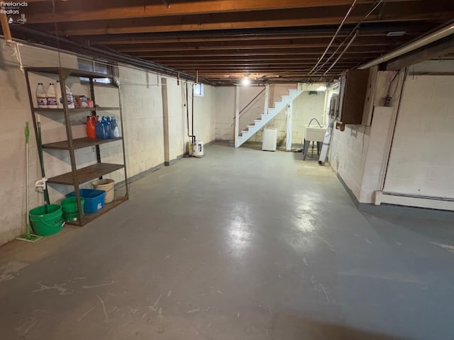 basement with a baseboard radiator and sink