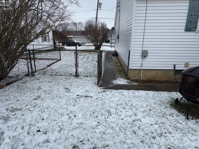 yard covered in snow with an outdoor fire pit