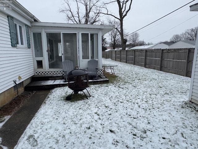 yard layered in snow with a sunroom