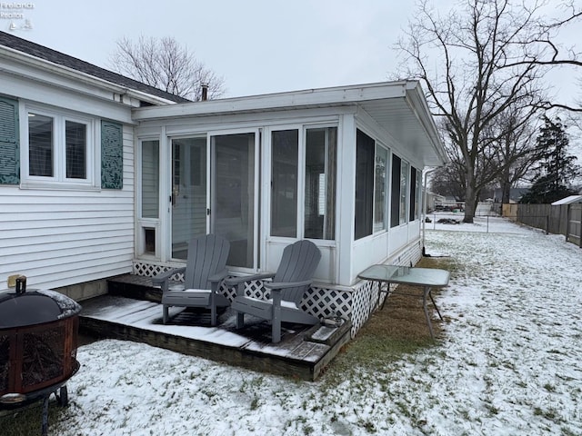 snow covered deck with a sunroom and area for grilling