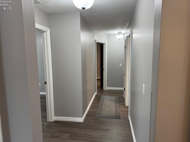 corridor with dark hardwood / wood-style flooring